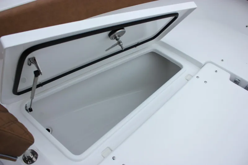 Slide: The Image of Open storage compartment on 2026 Sea Hunt Ultra 265 SE boat with cushioned seating. - 53