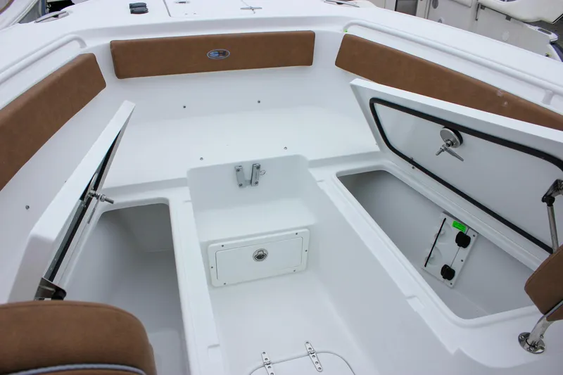 Slide: The Image of 2026 Sea Hunt Ultra 265 SE boat interior with open storage compartments and cushioned seating. - 55