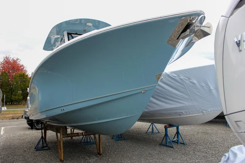 Slide: The Image of 2026 Sea Hunt Ultra 265 SE boat displayed outdoors, surrounded by other boats. - 61
