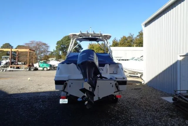 Slide: The Image of 2015 Robalo R247 Dual Console boat with outboard motor, parked outdoors. - 12