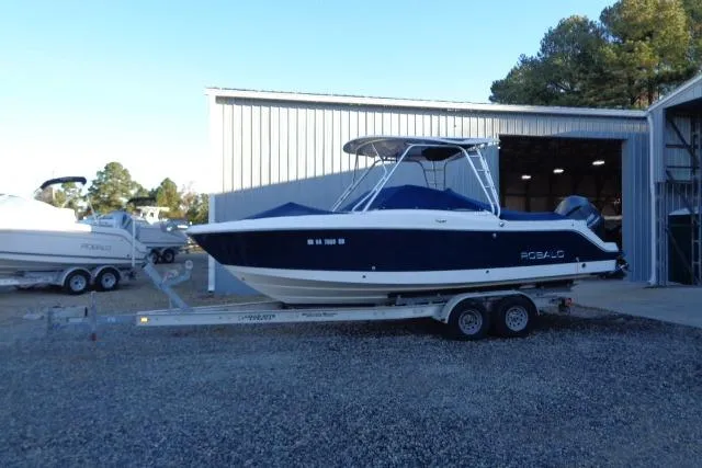 Slide: The Image of 2015 Robalo R247 Dual Console boat on trailer outside storage facility. - 2