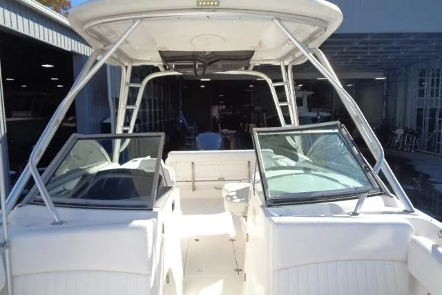 Slide: The Image of 2015 Robalo R247 Dual Console boat with open deck and windshield, docked indoors. - 20