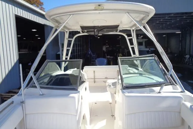 Slide: The Image of 2015 Robalo R247 Dual Console boat with open deck and windshield, docked in a marina. - 21