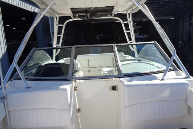 Slide: The Image of 2015 Robalo R247 Dual Console boat with white seating and windshield in a marina setting. - 22
