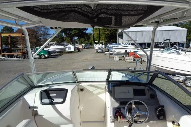 Slide: The Image of 2015 Robalo R247 Dual Console boat interior with Garmin navigation system at a marina. - 23