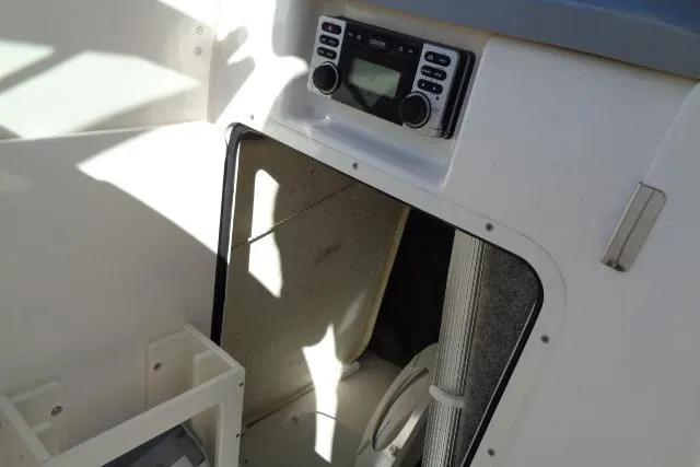 Slide: The Image of 2015 Robalo R247 Dual Console interior with radio and storage compartment. - 25