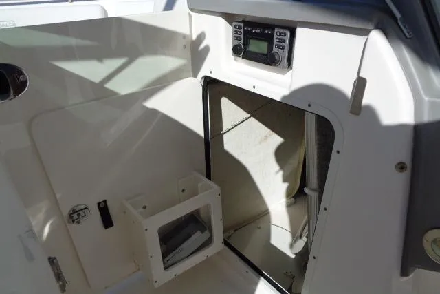 Slide: The Image of 2015 Robalo R247 Dual Console interior with storage compartment and control panel. - 26