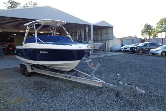Slide: The Image of 2015 Robalo R247 Dual Console boat on trailer, parked outside a garage. - 3