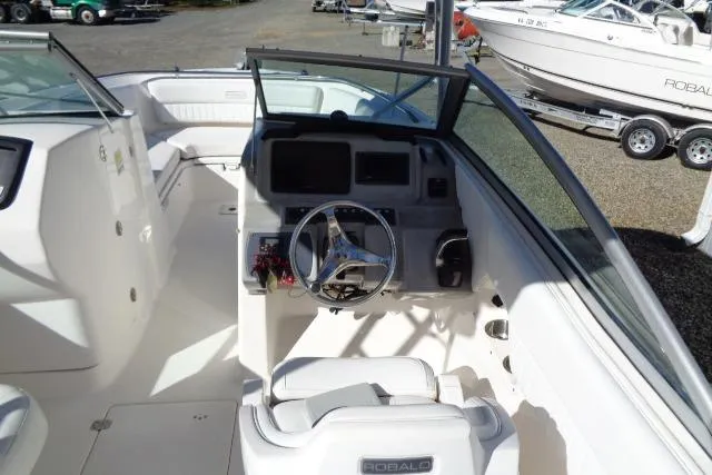 Slide: The Image of 2015 Robalo R247 Dual Console boat interior with steering wheel and seating. - 32