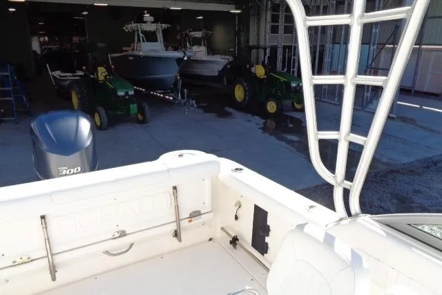 Slide: The Image of 2015 Robalo R247 Dual Console boat in a garage with tractors and equipment. - 36