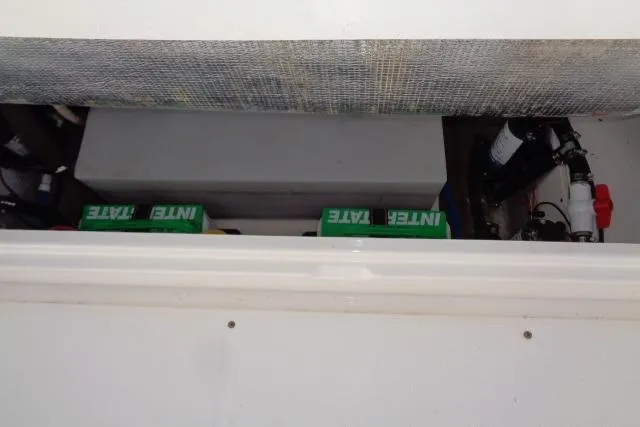 Slide: The Image of 2015 Robalo R247 Dual Console boat storage compartment with batteries and equipment. - 41