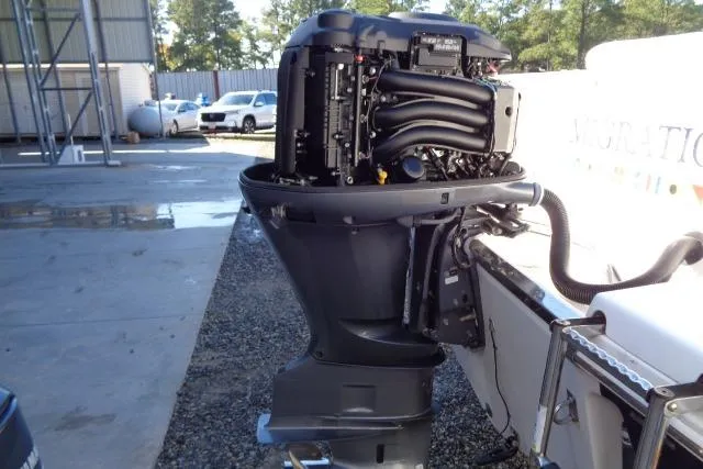 Slide: The Image of 2015 Robalo R247 Dual Console outboard motor, detailed view in a marina setting. - 50