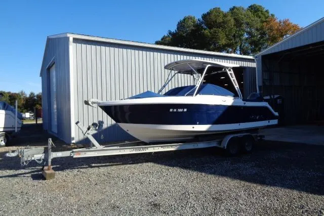 Slide: The Image of 2015 Robalo R247 Dual Console boat on trailer near metal building. - 7