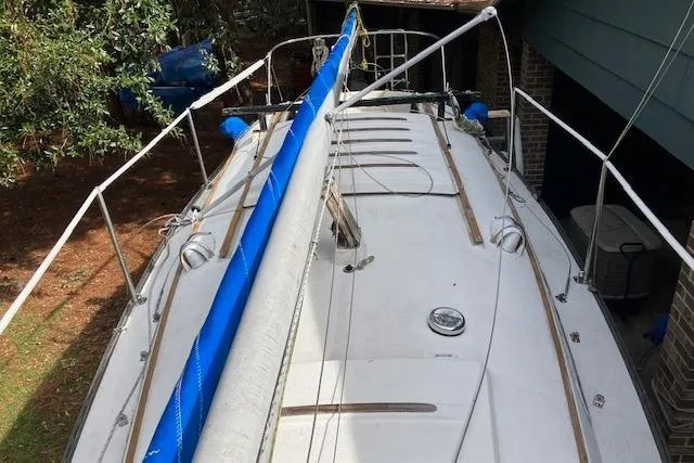 Slide: The Image of 1979 Chrysler 26 sailboat deck with blue sail cover, docked near a house. - 10