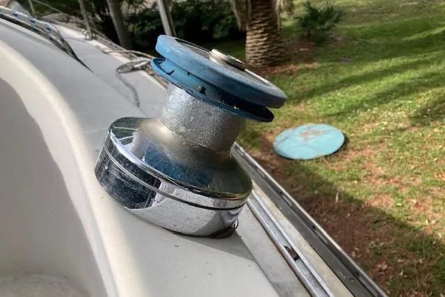 Slide: The Image of 1979 Chrysler 26 sailboat winch on deck, with grassy background. - 20