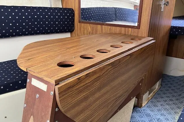 Slide: The Image of 1979 Chrysler 26 interior with wooden table and blue cushioned seating. - 23