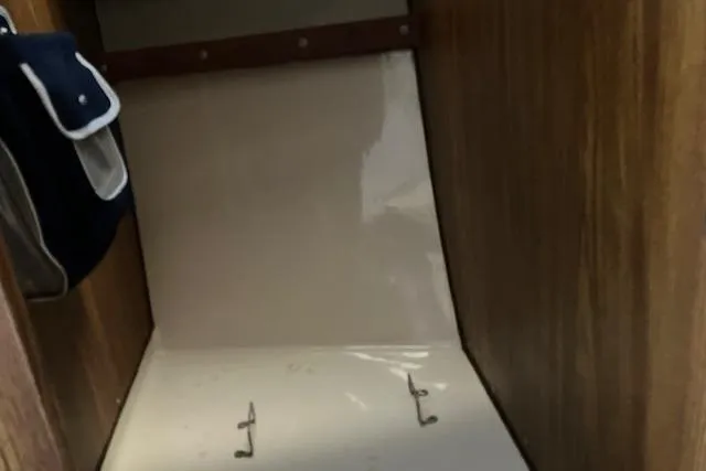 Slide: The Image of 1979 Chrysler 26 interior storage compartment with hooks and wooden paneling. - 27