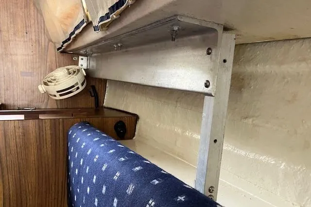 Slide: The Image of Interior of a 1979 Chrysler 26 boat with blue patterned seating and wood paneling. - 31