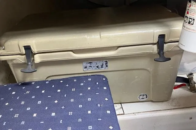 Slide: The Image of Beige cooler inside a 1979 Chrysler 26 boat, next to patterned cushion. - 35
