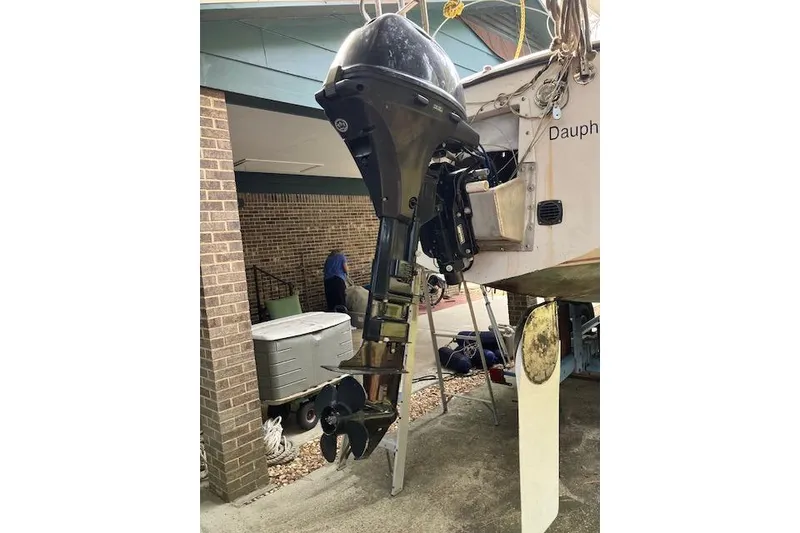 Slide: The Image of 1979 Chrysler 26 boat with an outboard motor, docked near a brick building. - 5