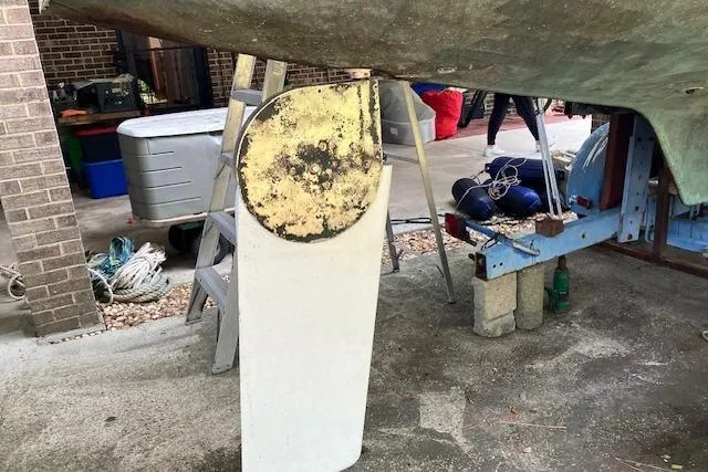 Slide: The Image of 1979 Chrysler 26 sailboat rudder under maintenance in a workshop setting. - 6