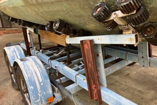 Slide: The Image of 1979 Chrysler 26 boat on a weathered blue trailer with rusted metal parts. - 7