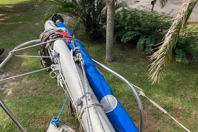 Slide: The Image of 1979 Chrysler 26 sailboat mast and rigging on grassy area with palm trees. - 9