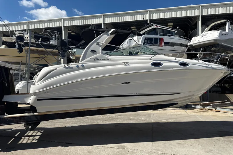 The Image of 2004 Sea Ray 280 Sundancer boat in storage, side view under clear blue sky. - 0