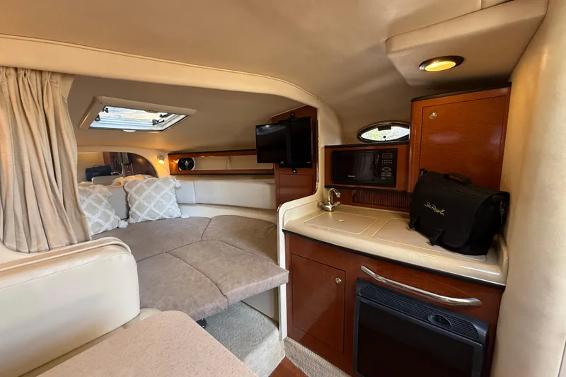 Slide: The Image of Interior of 2004 Sea Ray 280 Sundancer with cozy cabin, kitchenette, and seating area. - 13