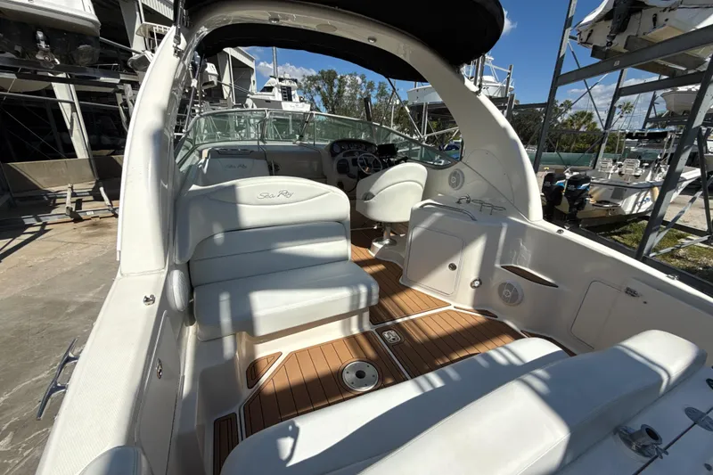 Slide: The Image of 2004 Sea Ray 280 Sundancer boat interior with white seating and wood flooring. - 3
