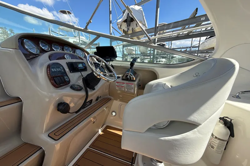 Slide: The Image of 2004 Sea Ray 280 Sundancer helm with steering wheel, gauges, and captain's chair. - 5