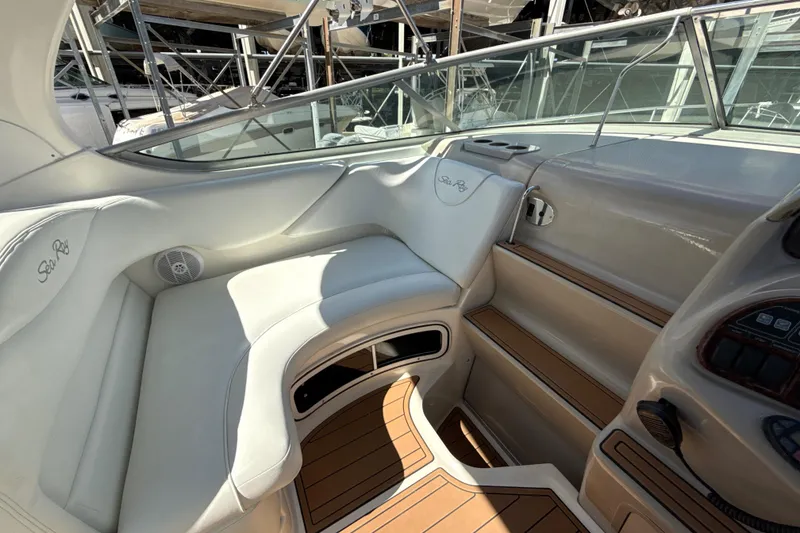 Slide: The Image of 2004 Sea Ray 280 Sundancer interior with white seating and wood accents. - 6