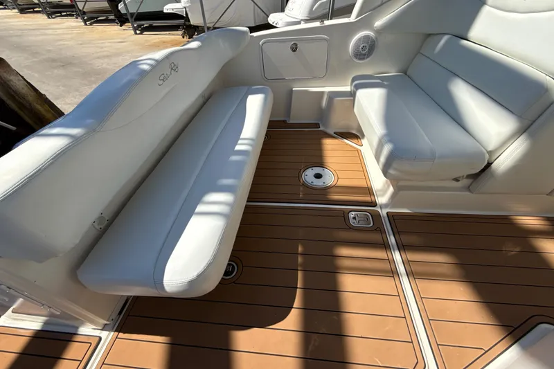 Slide: The Image of 2004 Sea Ray 280 Sundancer interior with white seating and teak-style flooring. - 8