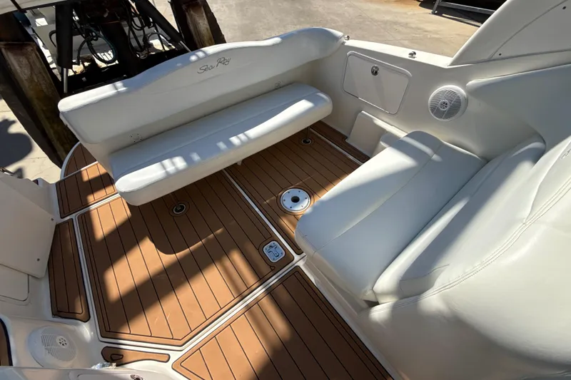 Slide: The Image of 2004 Sea Ray 280 Sundancer boat interior with white seating and teak flooring. - 9