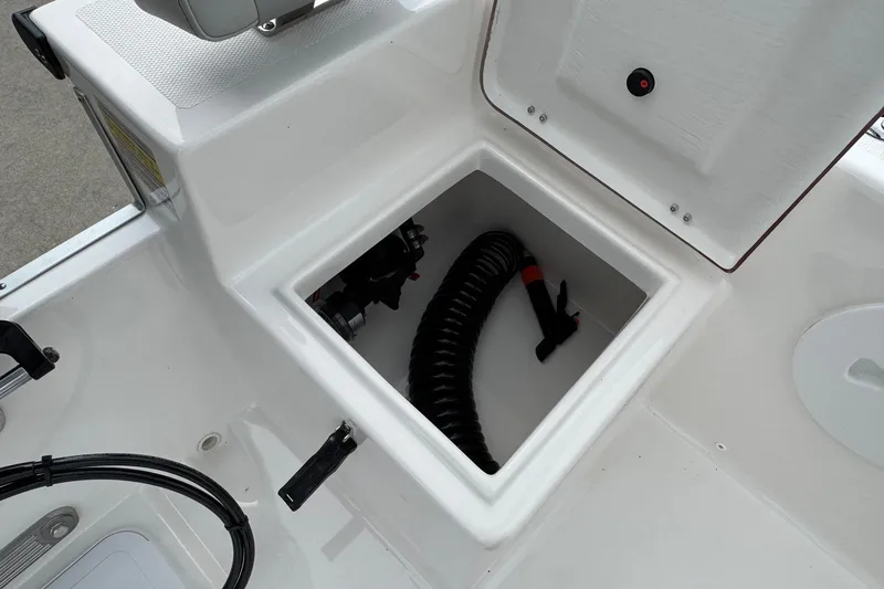 Slide: The Image of 2025 Bay Rider 2060 boat storage compartment with coiled hose and open hatch. - 17