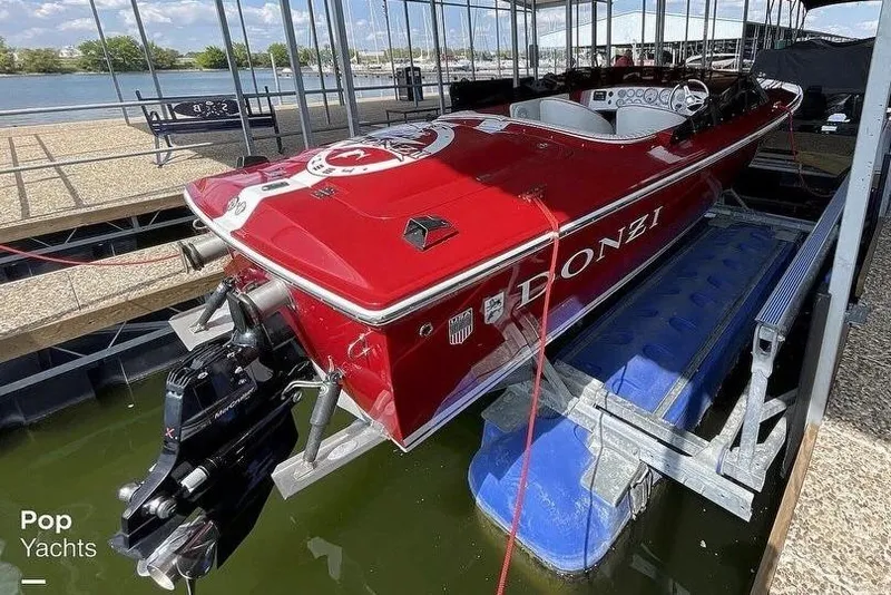 Slide: The Image of 2017 Donzi 22 Classic boat in red, docked on a lift at a marina. - 17
