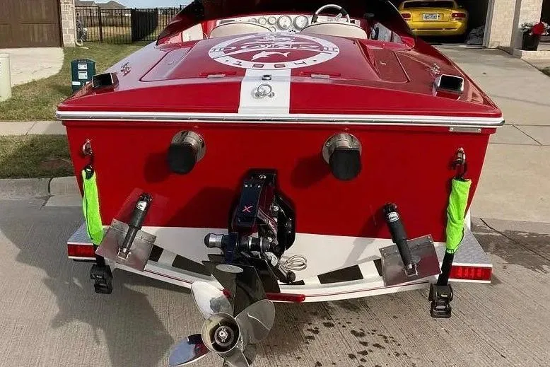 Slide: The Image of 2017 Donzi 22 Classic boat, red with white stripe, rear view showing propeller and exhaust. - 3