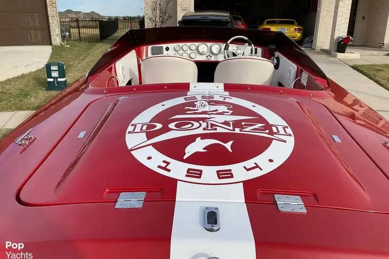 Slide: The Image of 2017 Donzi 22 Classic boat with red and white design, parked in a driveway. - 4