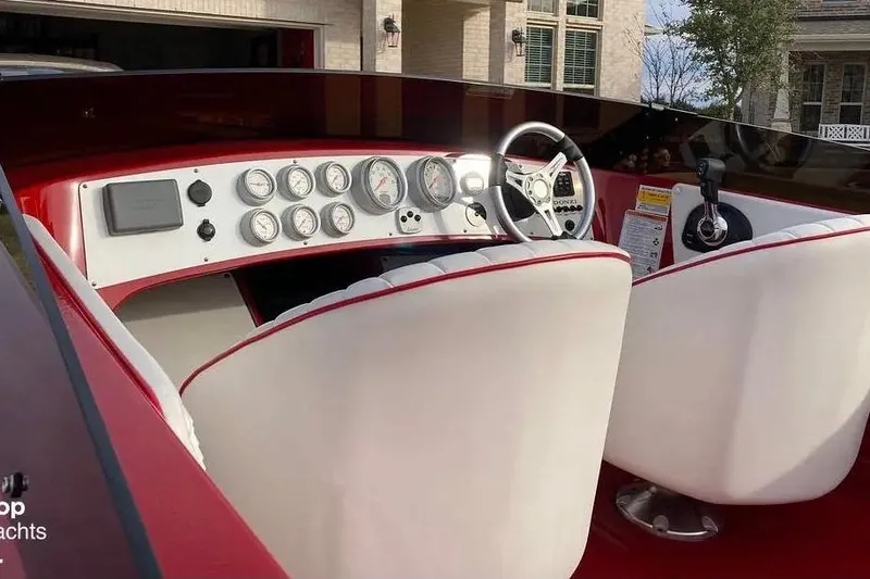 Slide: The Image of Interior of a 2017 Donzi 22 Classic boat with white and red seating and dashboard gauges. - 7