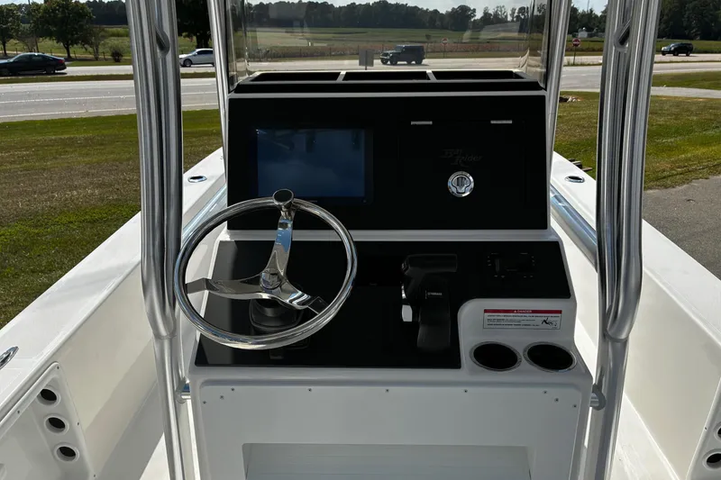 Slide: The Image of 2026 Bay Rider 2260 boat console with steering wheel and controls, parked near a road. - 10