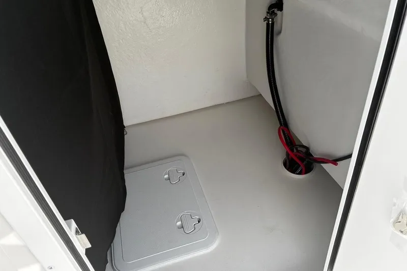 Slide: The Image of Interior view of 2026 Bay Rider 2260 boat compartment with storage hatch and wiring. - 19