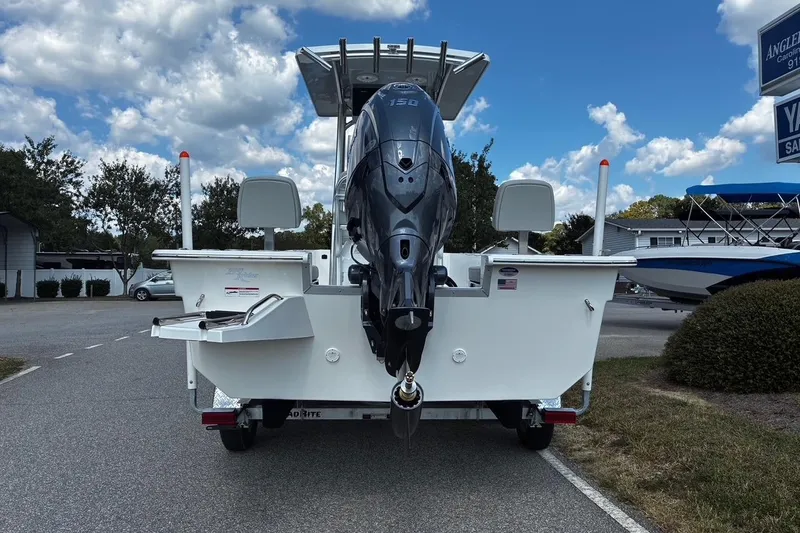 Slide: The Image of 2026 Bay Rider 2260 boat with outboard motor, parked outdoors under a partly cloudy sky. - 4