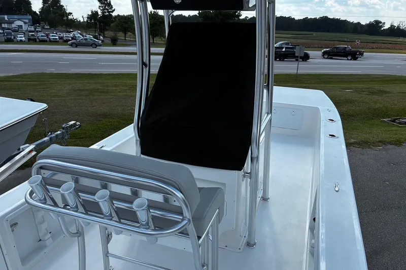 Slide: The Image of 2026 Bay Rider 2260 boat with sleek seating and rod holders, parked near a road. - 5