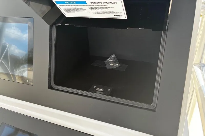 Slide: The Image of Open storage compartment on a 2026 Bay Rider 2260 boat with a checklist notice. - 7