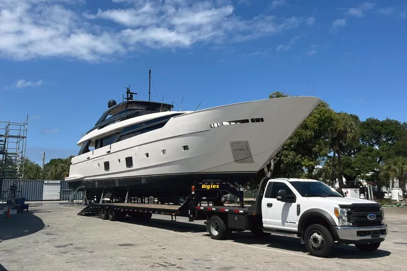Slide: The Image of 2022 Sanlorenzo SL 120A yacht on trailer, parked outdoors under clear blue sky. - 10