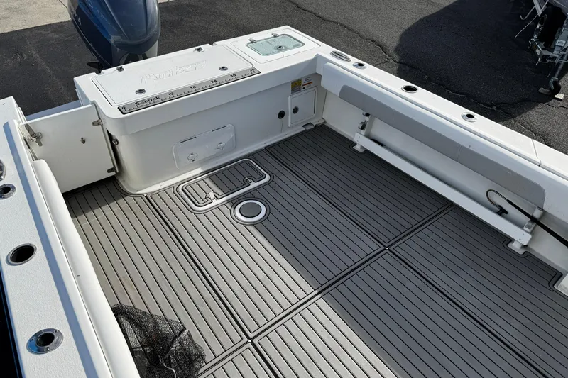 Slide: The Image of 2021 Parker 2320 Sport Cabin boat deck with storage compartments and fishing net. - 10