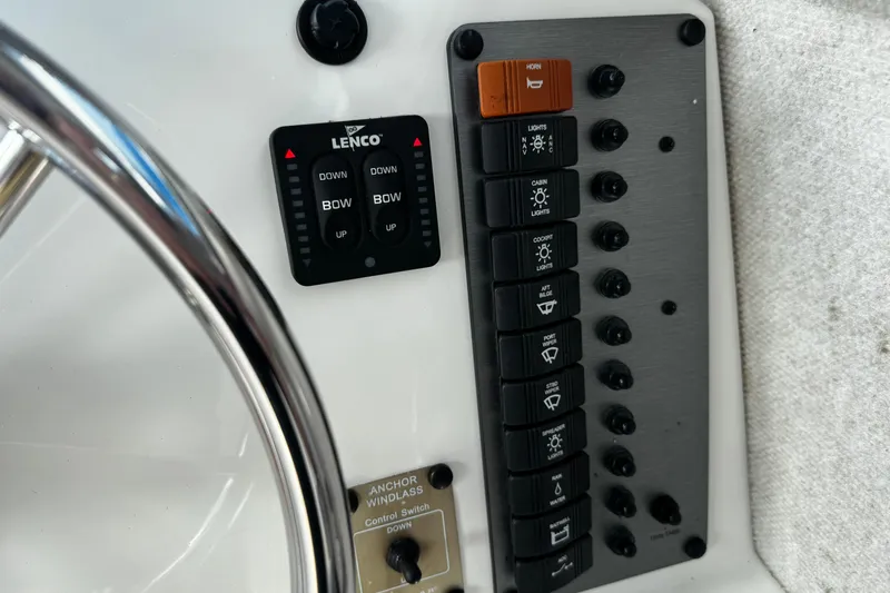 Slide: The Image of Control panel of a 2021 Parker 2320 Sport Cabin boat with switches and steering wheel. - 16