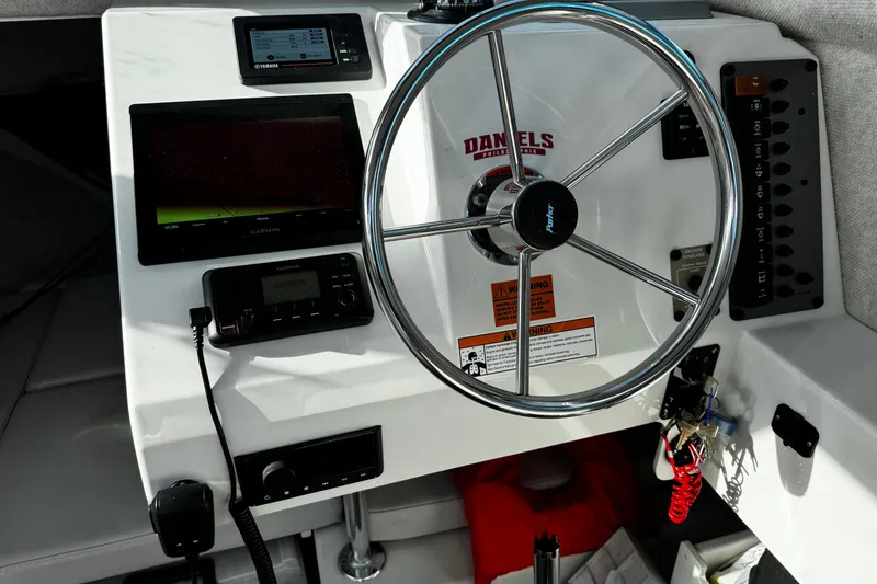 Slide: The Image of 2021 Parker 2320 Sport Cabin dashboard with steering wheel and navigation equipment. - 22