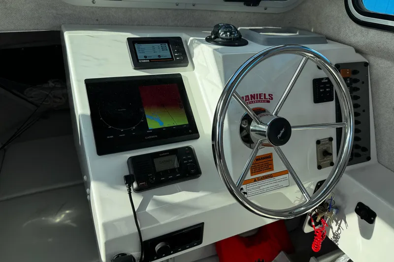 Slide: The Image of 2021 Parker 2320 Sport Cabin helm with Garmin navigation and steering wheel. - 23