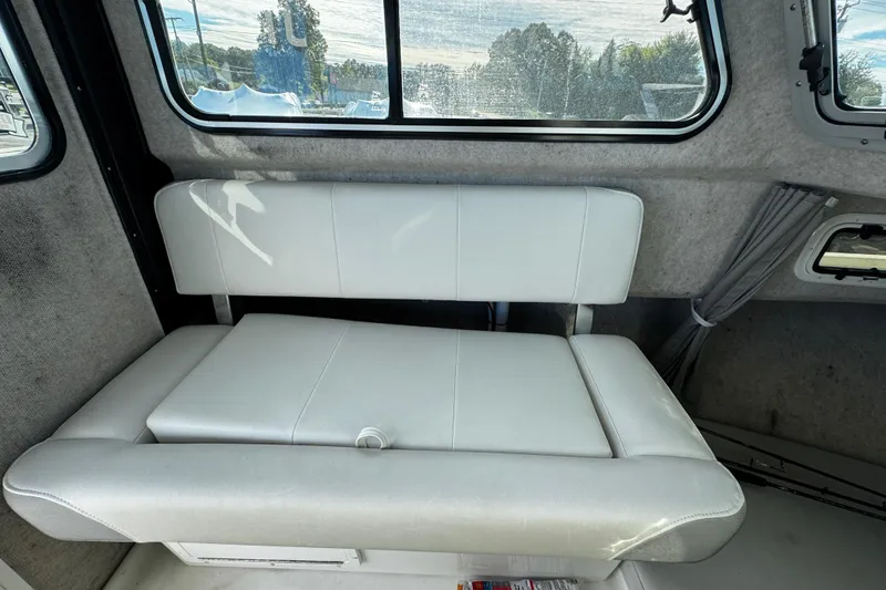 Slide: The Image of 2021 Parker 2320 Sport Cabin interior with cushioned seating and window view. - 25